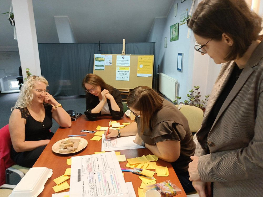 Grupa kobiet pracująca przy stole pod okiem Agnieszki Michalskiej-Żyły